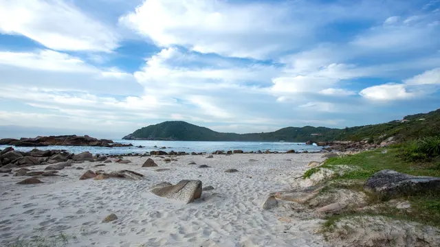 Mar de Garopaba com pedras e céu nublado