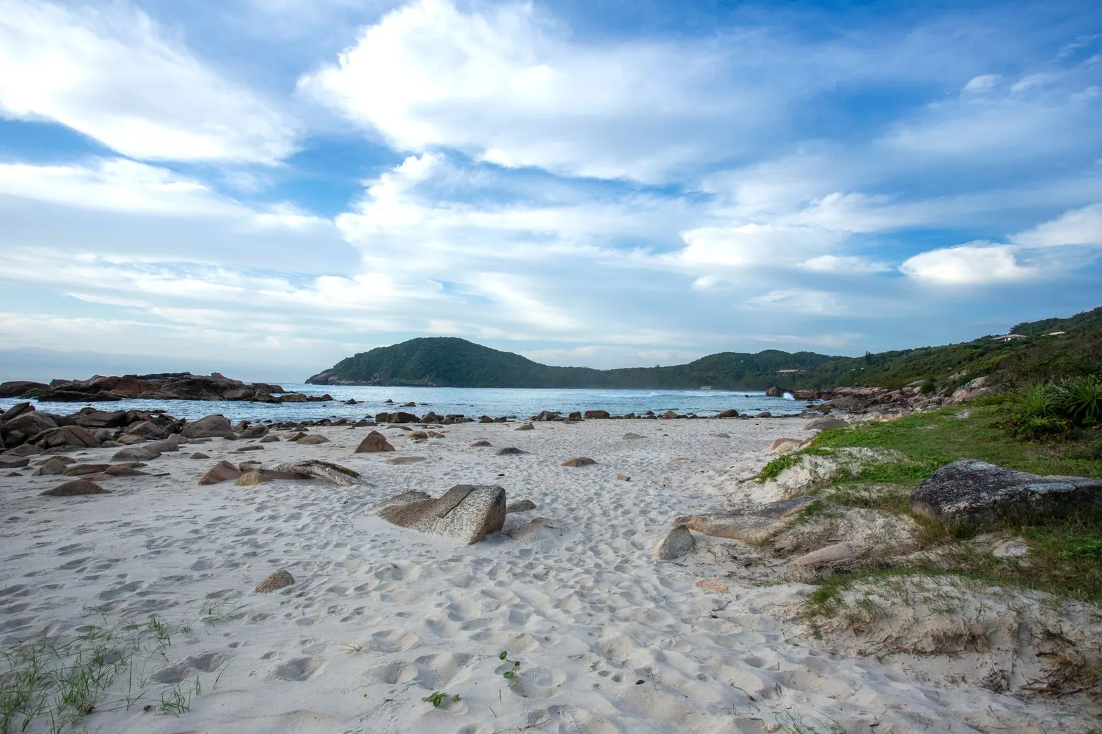 Mar de Garopaba com pedras e céu nublado